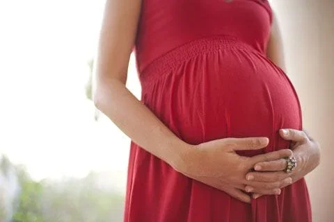Pregnant woman in a red dress.