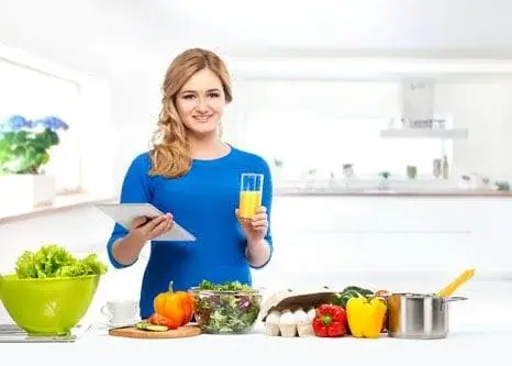 Woman cooking with vegetables in kitchen.